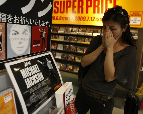 A Japanese fan reacts as she looks at commemorative stand for Michael Jackson at a music shop in Tokyo 