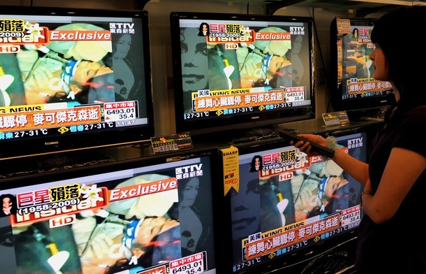 A woman checks the breaking news of Michael Jackson's death at an electronic store in Hsintien, Taipei