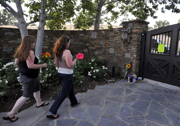 Michael Jackson Fans carry flowers towards the front gate of Neverland in Los Olivos